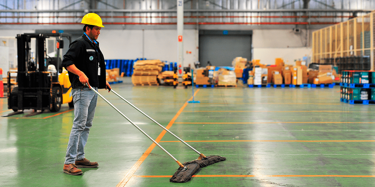 hombre realizando limpieza de una nave industrial profesional