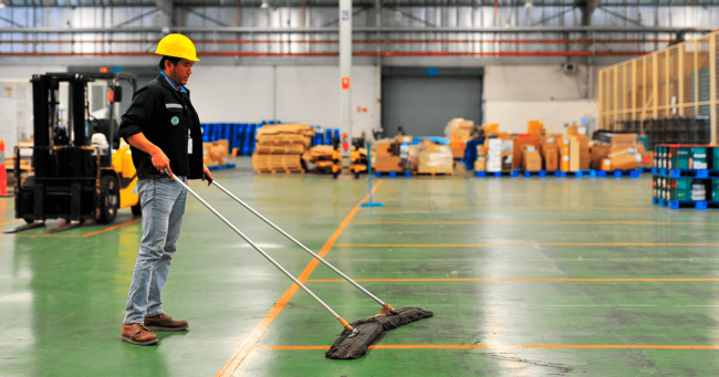 hombre realizando limpieza de una nave industrial profesional